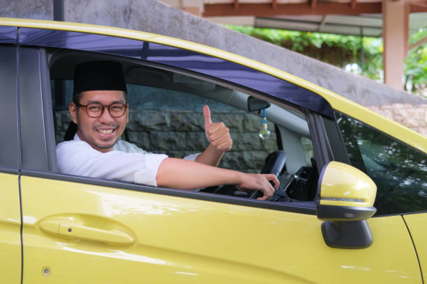 istock Moslem Asian man smiling and give thumb up from inside his car 1471996294
