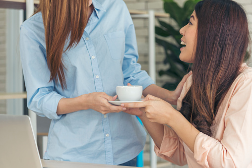 Woman hands giving black coffee cup to colleague at office desk together. Close up hands holding coffee tea cup with friendship Business teamwork caffeine hot tea cup freshness happy lifestyle