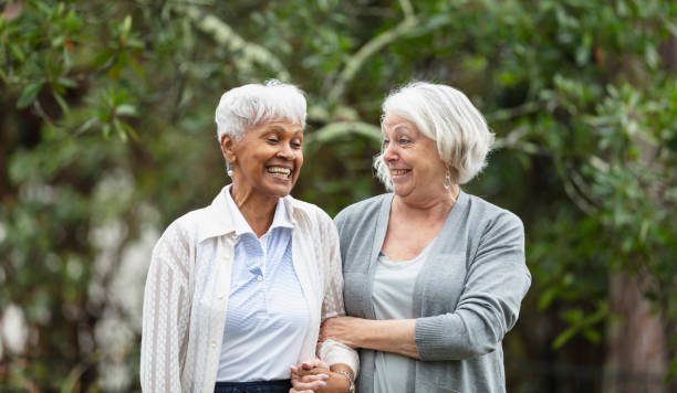 Senior women walking, talking in back yard, smiling