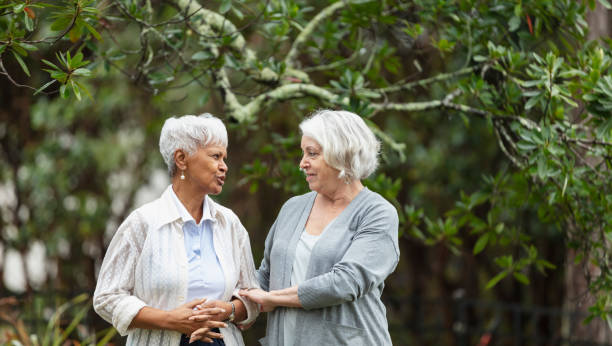 istock Senior women walking, talking in back yard 1472003218