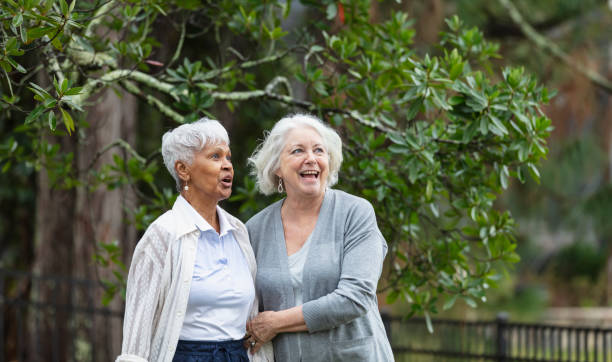 istock Senior women walking, talking in back yard, laughing 1472003251