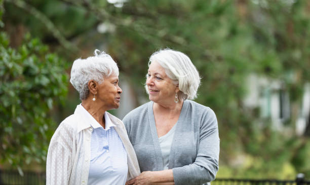 istock Senior women walking, talking in back yard, smiling 1472003260