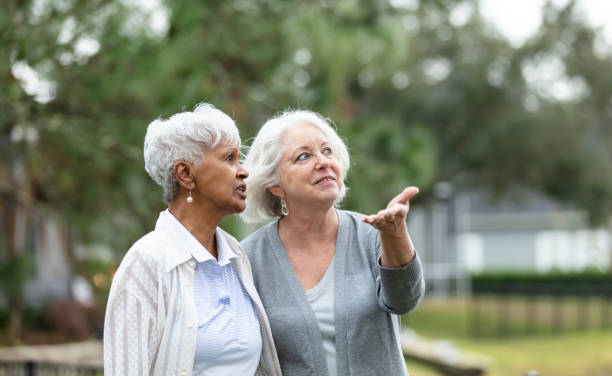 istock Senior women walking, talking in back yard 1472003307