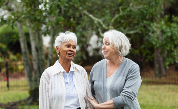 istock Senior women walking, talking, smiling in back yard 1472003319