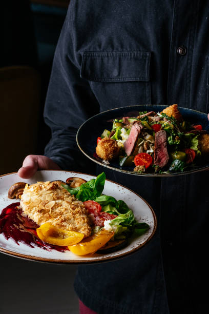istock a man holds a plate in which a chicken schnitzel. restaurant men 1472004461