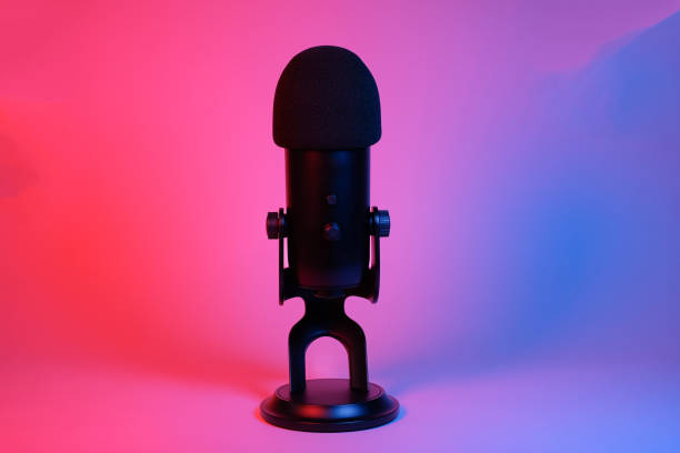 istock a black microphone on black background under the neon light. podcasting, singing, and recording background. 1472007930