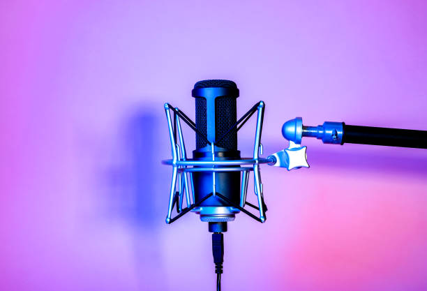 istock a black microphone on black background under the neon light. podcasting, singing, and recording background. 1472007934