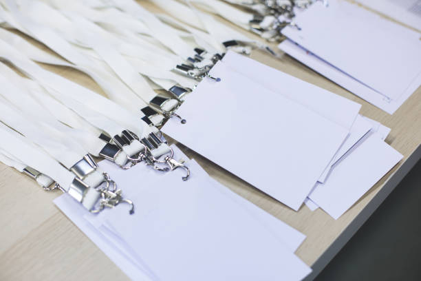istock Registration desk table, process of checking in on a conference congress forum event, visitors and attendees receiving a name badge and entrance wristband bracelet and register electronic ticket 1472009253