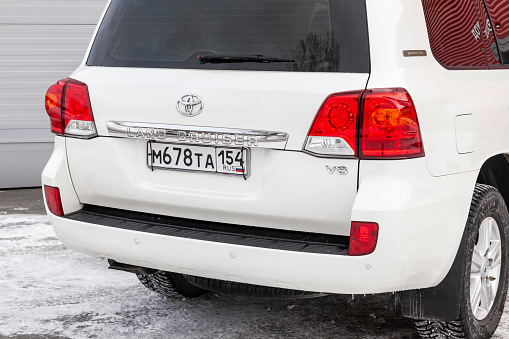 Novosibirsk, Russia - 03.04.2023: Rear view of Toyota Land Cruiser 200 j200 2013 year white color after cleaning before sale in a sunny day on parking. Japan SUV car.