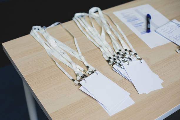 istock Registration desk table, process of checking in on a conference congress forum event, visitors and attendees receiving a name badge and entrance wristband bracelet and register electronic ticket 1472009420