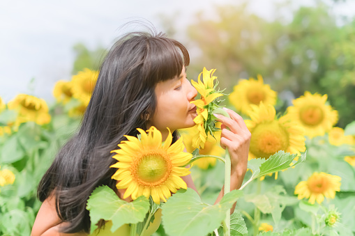 Happy Women in SunFlowers Garden,Portrait Cute Girl Joy Cheerful Happiness in Nature Spring Flower,Fasion Tourism Travel Tropical Summer in Holidays Concept.