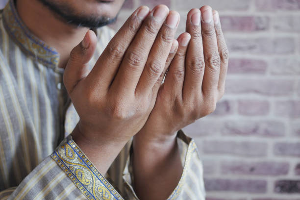istock muslim man keep hand in praying gestures during ramadan, Close up 1472019647