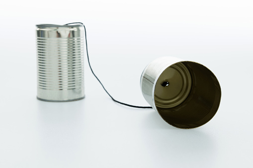 Silver tin can phone on white background.