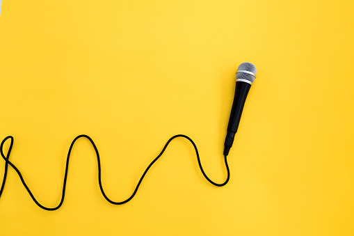 Wired microphone on yellow background.
