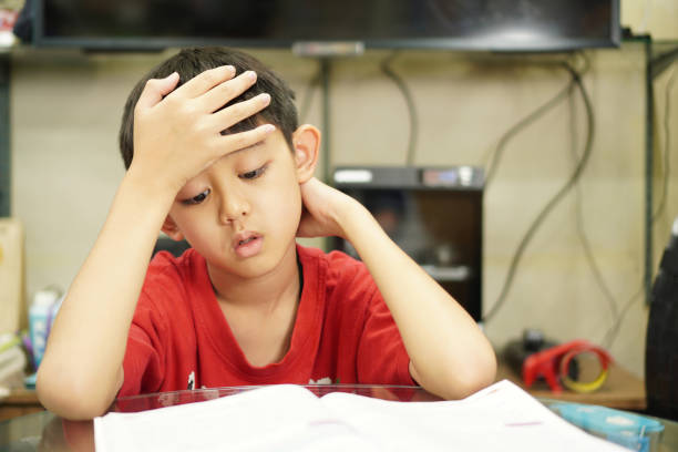 istock The picture shows a little boy sitting, reading, thinking, doing his science homework. 1472020635