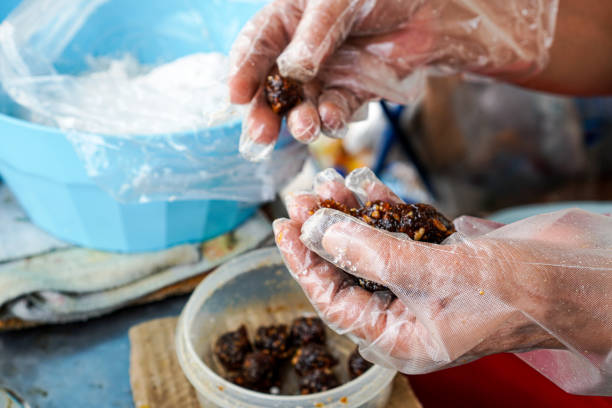 The picture shows a demonstration of making the stuffing for Thai Steamed Pork Dumplings, which has to be molded by hand.