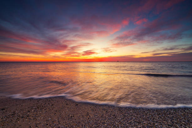 istock Beautiful sunrise over the sea shore 1472021046