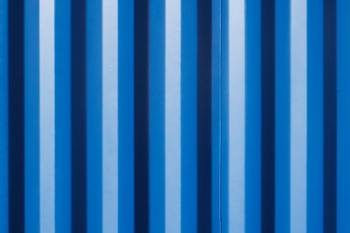 Close-up on part of a blue patterned metal fence.