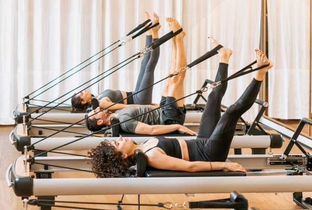 Group of people having pilates workout on equipment stock photo