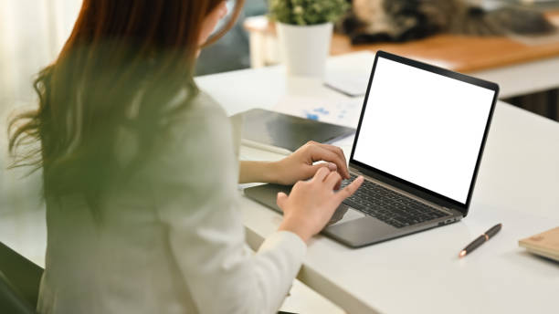 istock Side view of female manager sitting at her workplace and watching online presentation on laptop computer. 1472030181