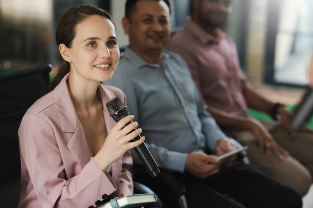 istock Curious woman asks question during business conference 1472030567