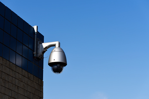 Surveillance camera against clear sky with copy space.