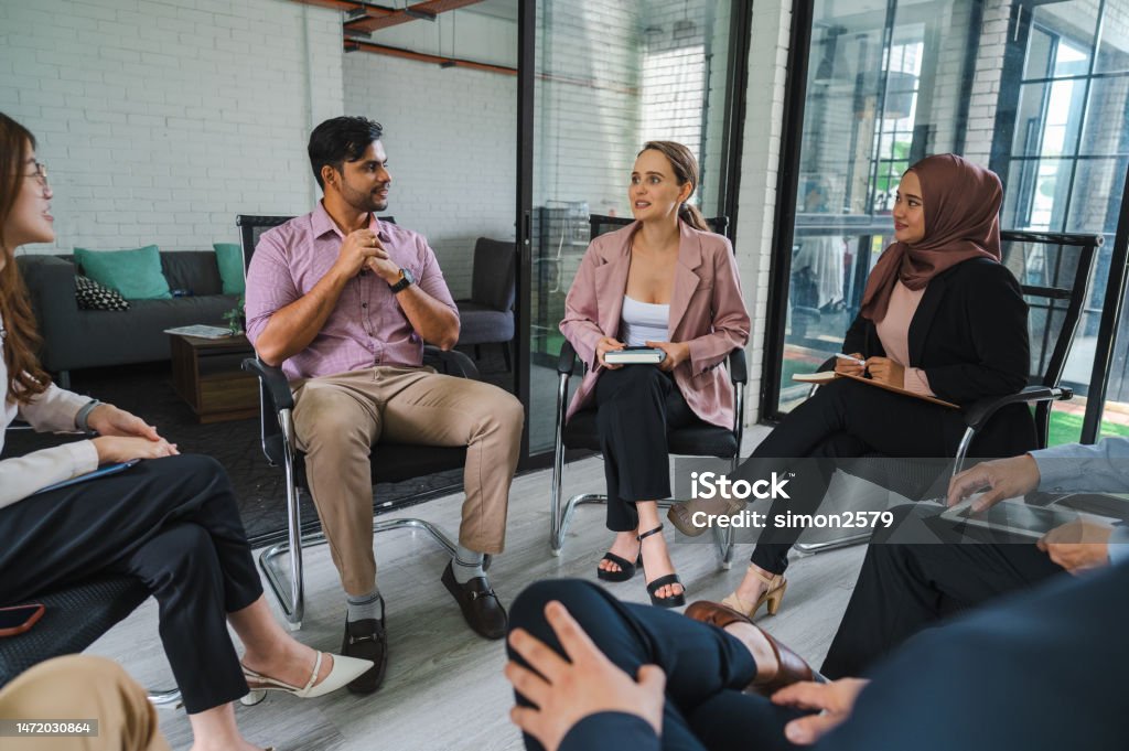 Voices Unheard: A Multiracial Business Seminar Question and Answer Session in a Modern Office A multiracial group of businesspeople having a seminar in a modern office Business Conference Stock Photo