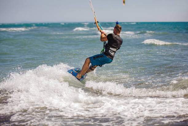 istock Young man having fun while kitesurfing on the sea. 1472031031