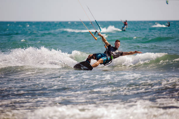 istock Young man having fun while kitesurfing on the sea. 1472031039