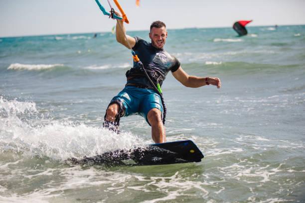 istock Young man having fun while kitesurfing on the sea. 1472031631