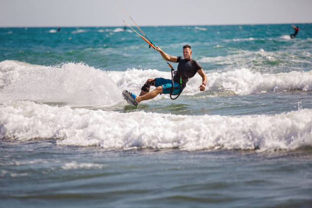 istock Young man having fun while kitesurfing on the sea. 1472031632