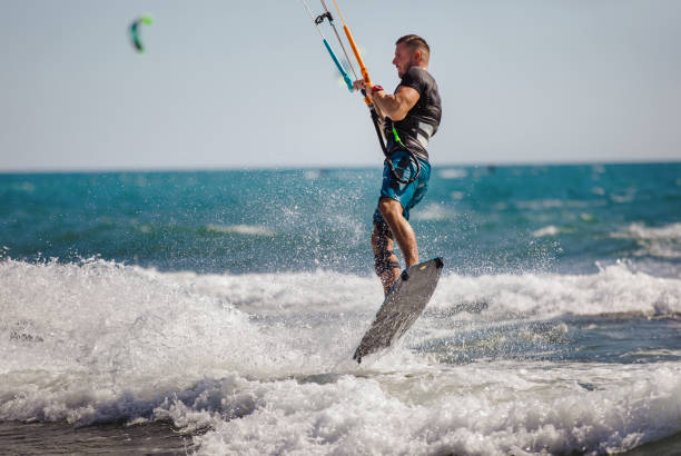 istock Young man having fun while kitesurfing on the sea. 1472031652