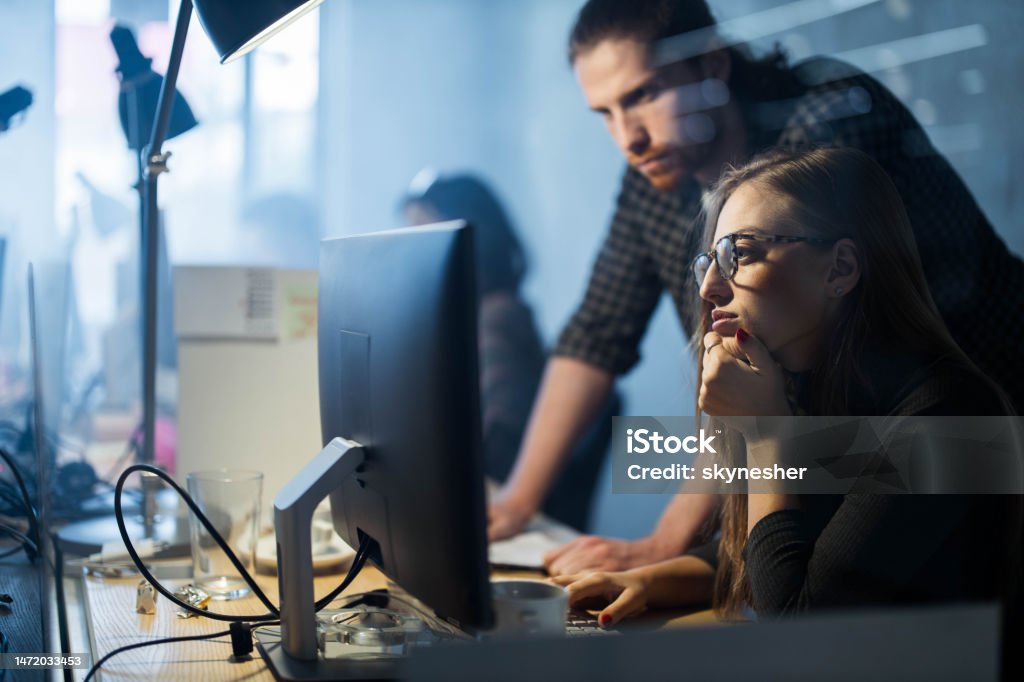Young Computer Programmers Cooperating While Reading Data On A Pc In ...