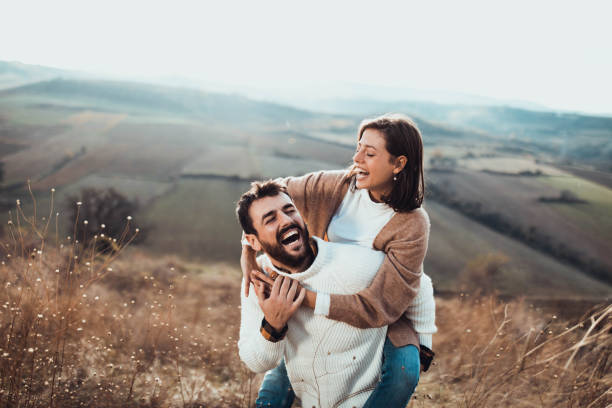 istock Young cheerful couple having fun while piggybacking on a hill. 1472034893