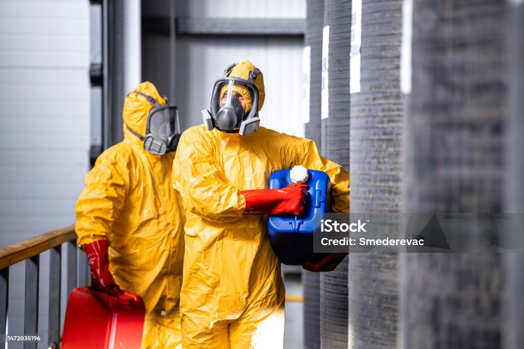 Fully Protected Workers In Yellow Hazmat Suit Gas Masks And Gloves Fully Protected Workers In Yellow Hazmat Suit Gas Masks And Gloves