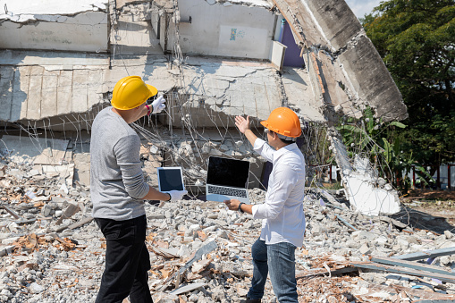 Demolition control supervisor and contractor discussing on demolish building.