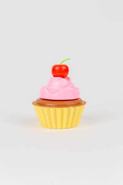 istock a pink delicious cake with cream cupcake children's plastic toy on a white background 1472036730