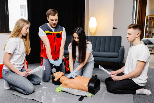 istock Group of people learning how to make first aid heart compressions with dummies during the training indoors 1472041200