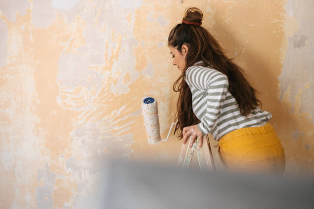 istock Woman painting a wall 1472046364
