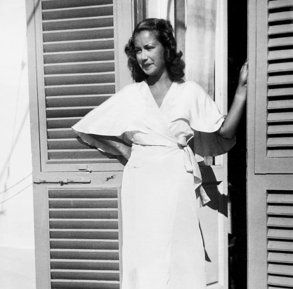 Beautiful young woman wearing bathrobe on balcony. 1939.