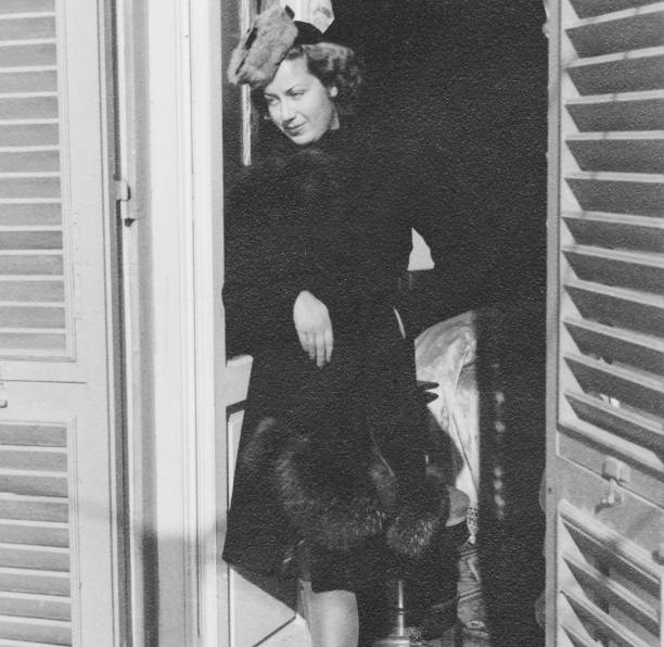 istock Beautiful young woman on balcony. 1939. 1472052684