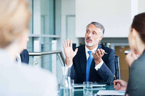 Gesturing businessman leading meeting in conference room  business caucasian meeting men stock pictures, royalty-free photos & images