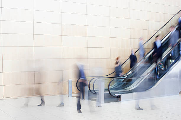 gens d'affaires sur des escalators - escalator photos et images de collection