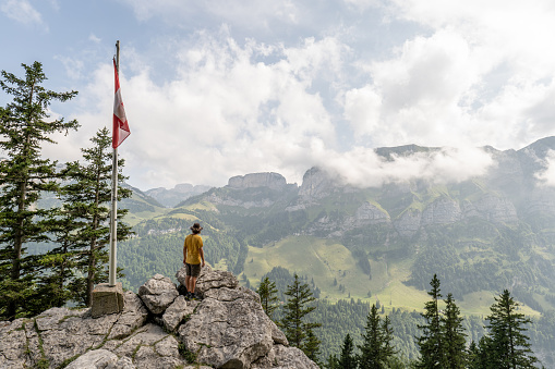 View of man hiking on mountain ridge looking at spectacular view in Appenzellerland Canton, Switzerland