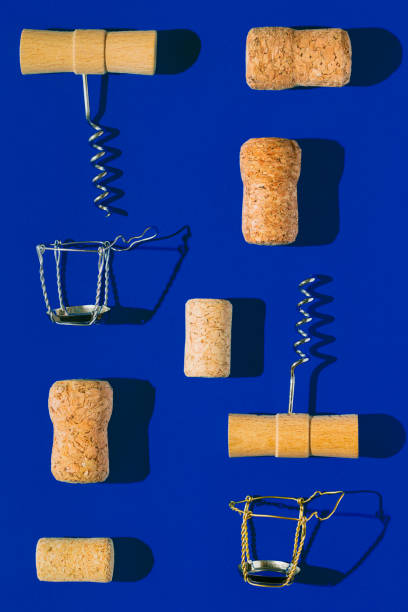 istock Creative composition made of champagne and wine bottle corks, corkscrews and metal wire muselet on blue sunlit background with shadow. Set of bottle caps from sparkling wine. Summer party drink concept 1472054471