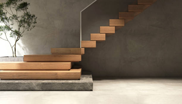 scala a sbalzo in legno a forma di l moderna ed elegante con scala a base in granito nero, balaustre in vetro temperato, albero tropicale alla luce del sole dalla finestra sulla parete e sul pavimento in cemento lucido - concrete wall railing metal bannister foto e immagini stock