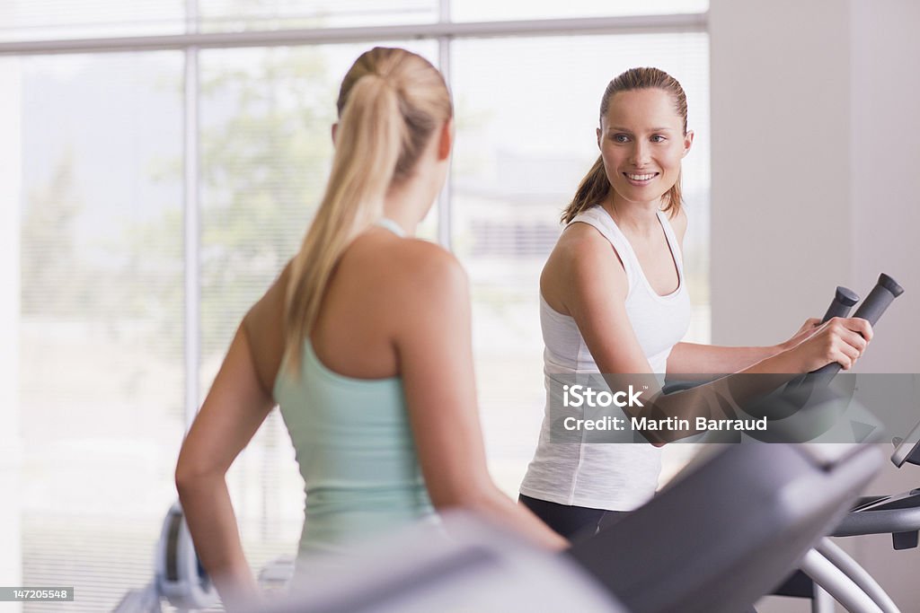 Smiling women using exercise equipment in gymnasium  18-19 Years Stock Photo