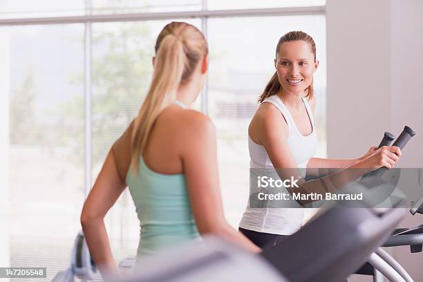 Smiling Women Using Exercise Equipment In Gymnasium Stock Photo - Download Image Now