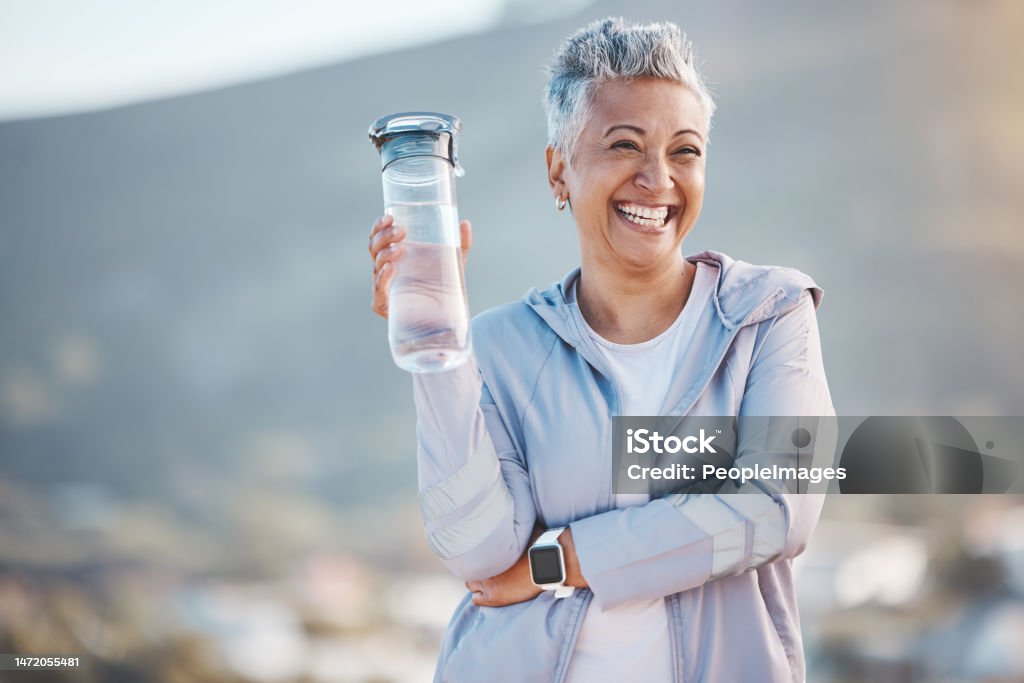 Fitness, happy or old woman with water bottle in nature to start training, exercise or hiking workout in New Zealand. Portrait, liquid or healthy senior person smiles with pride, goals or motivation Exercising Stock Photo