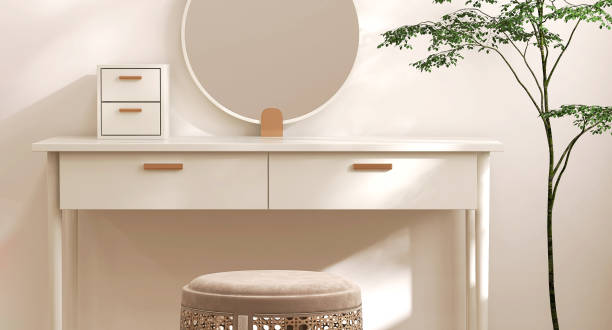istock Empty modern, minimal beige dressing table, gold handle drawer storage, round vanity mirror, stool, tree in cream wall bedroom in sunlight 1472056165